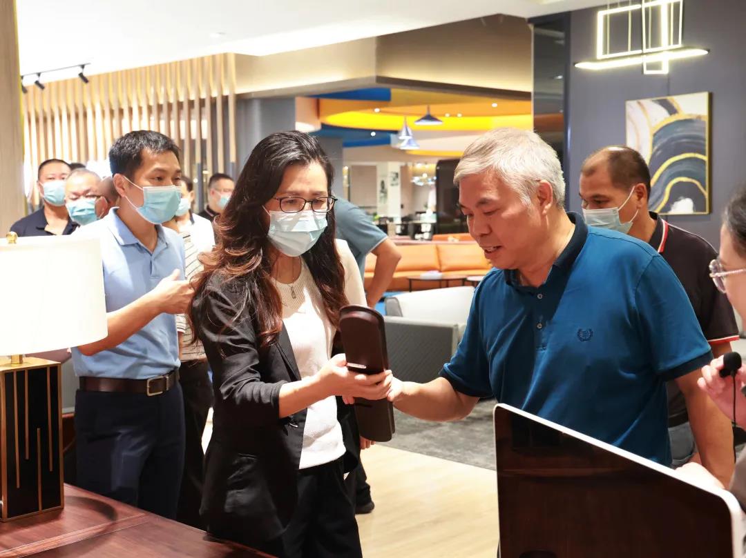 草莓视频污片家具集团董事副总裁黄云林为调研组展示实木办公家具产品